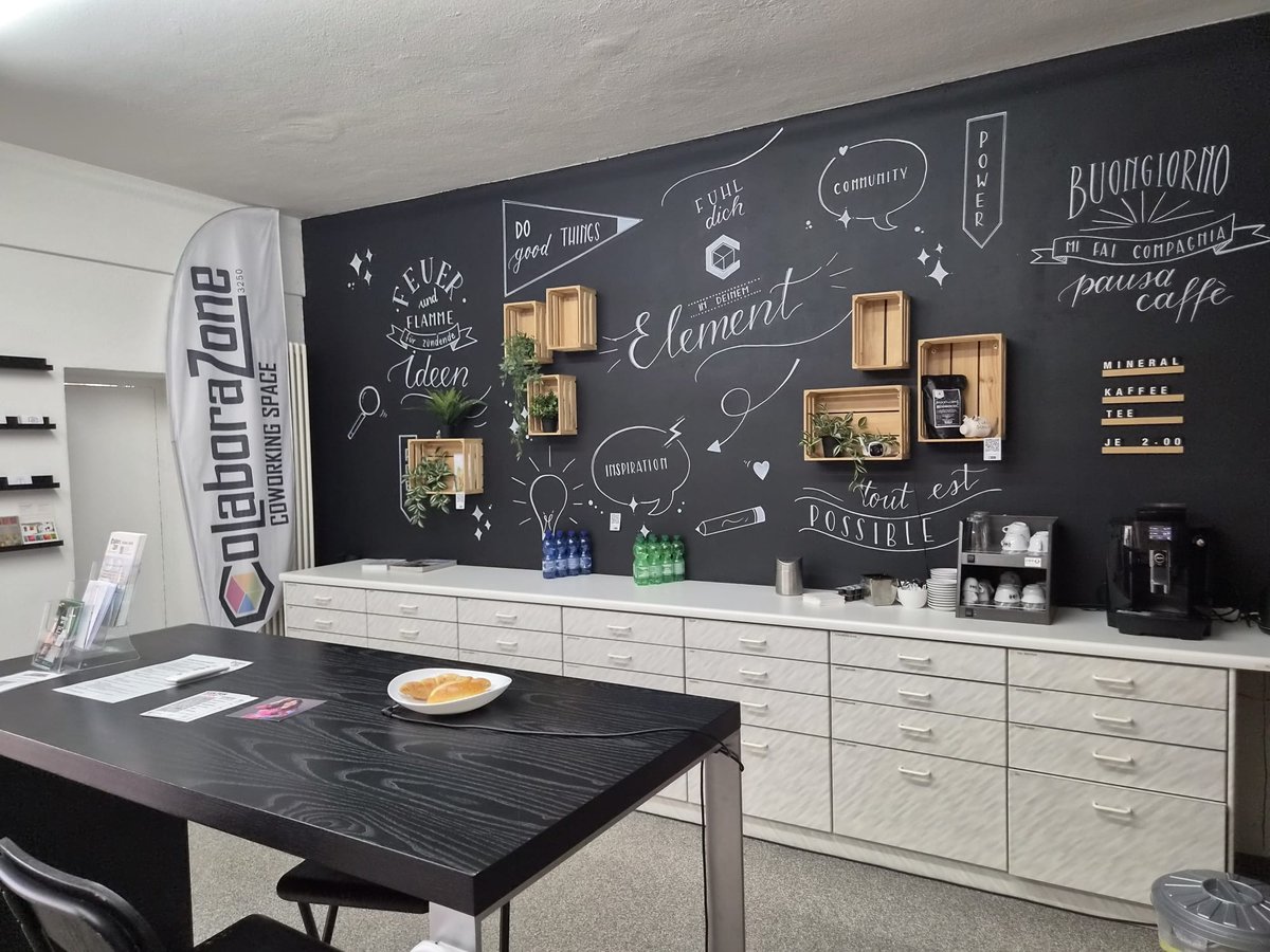 Verpflegungsecke der Colaborazone mit Kaffeemaschine, Tassen und dekorierter Wandtafel.